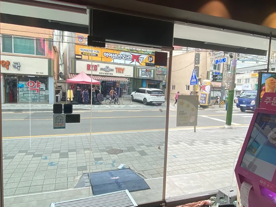 매장 내부에서 바라본 통유리 출입구 안전필름 시공 모습