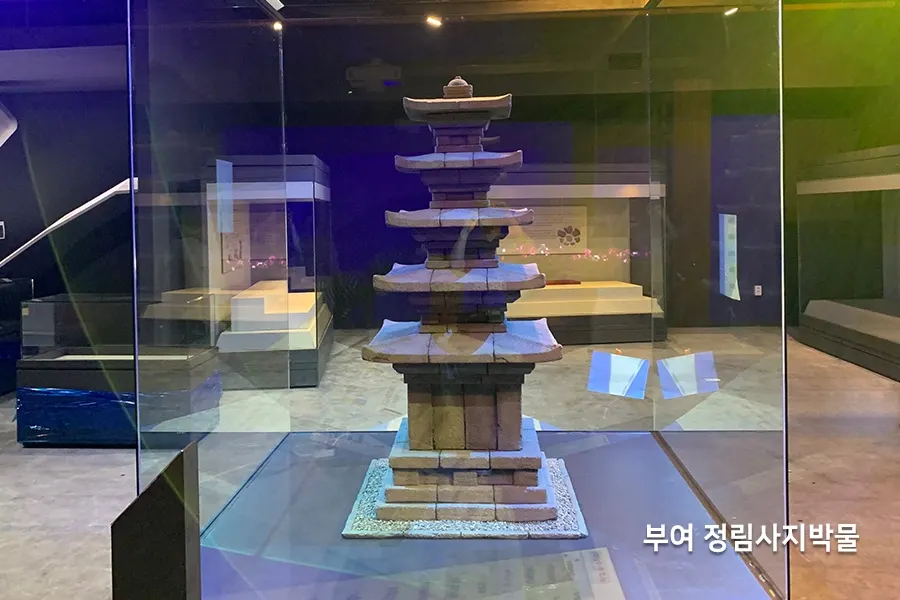 전시관 내부, 유물 모형이 놓인 진열장과 통유리 벽면