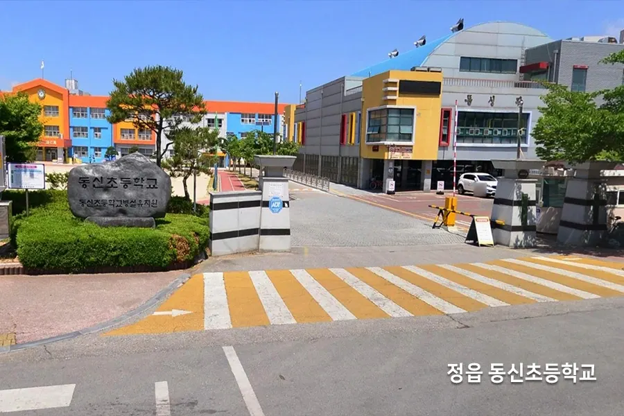 학교 정문 표지석과 컬러풀한 교사 건물 전경