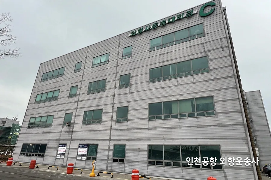 물류회사 사옥 건물 외관, 회색 외벽에 사무동 창호가 층별로 배치된 모습
