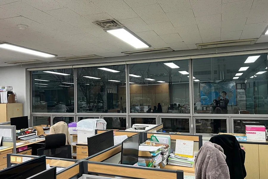 사무실 내부에서 바라본 창가 자리, 저녁 시간대의 실내 풍경