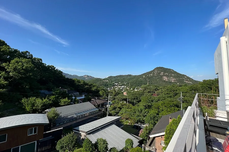 테라스에서 바라본 산자락과 마을 전경, 맑은 하늘